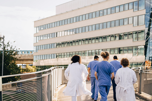 Nurses and Doctors walking into a hospital.