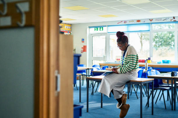 Teacher sitting in classroom.