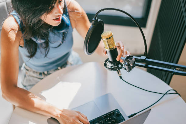 Woman recording on a microphone.