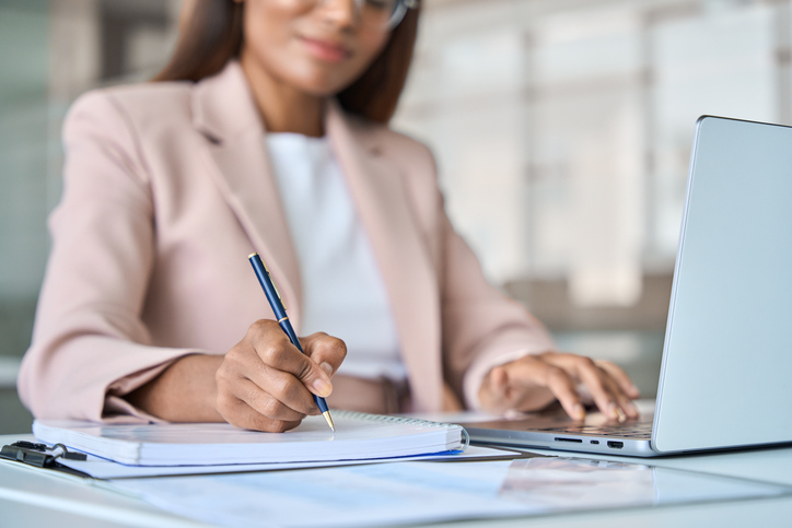 woman in office writing in notebook