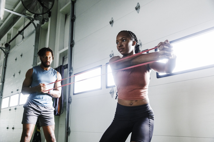 athletic trainer working with client at gym