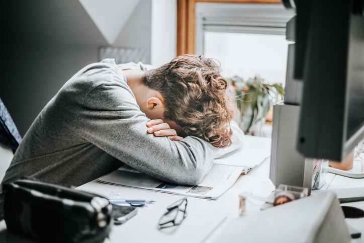 Stressed out man with his head down on desk