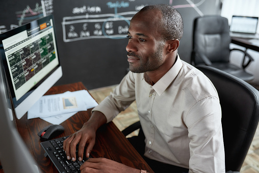 Computer system analyst typing and looking at screen